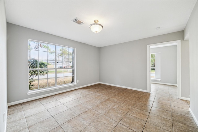unfurnished room featuring light tile patterned flooring, baseboards, and visible vents