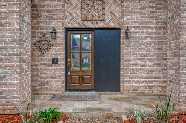 doorway to property with brick siding