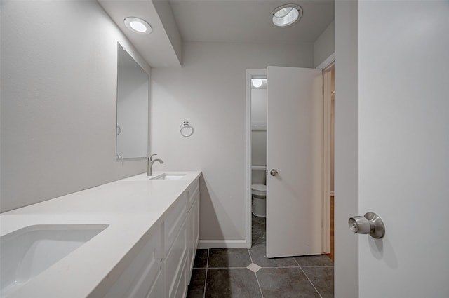 full bathroom with a sink, tile patterned flooring, toilet, and double vanity