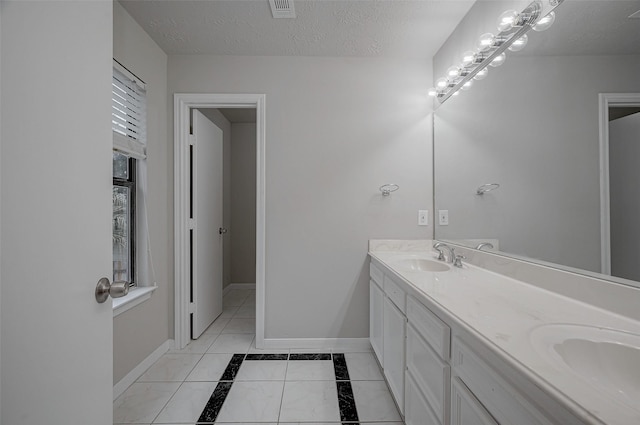 full bath featuring baseboards, a textured ceiling, visible vents, and a sink