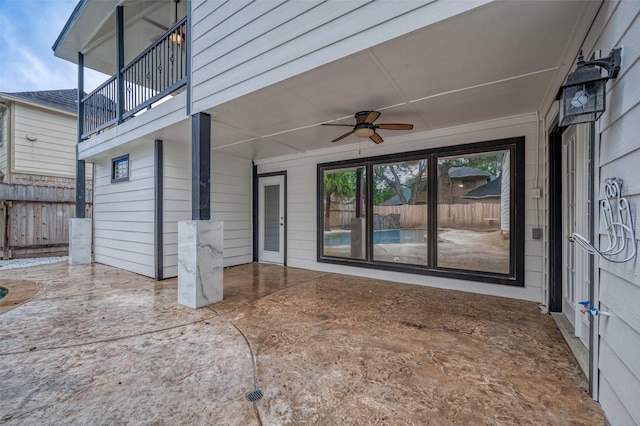 view of patio / terrace with fence, ceiling fan, and a balcony