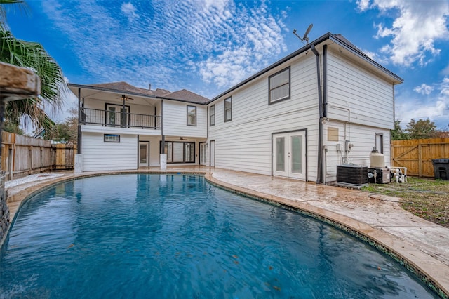 view of pool featuring a patio, a fenced backyard, french doors, a fenced in pool, and a ceiling fan