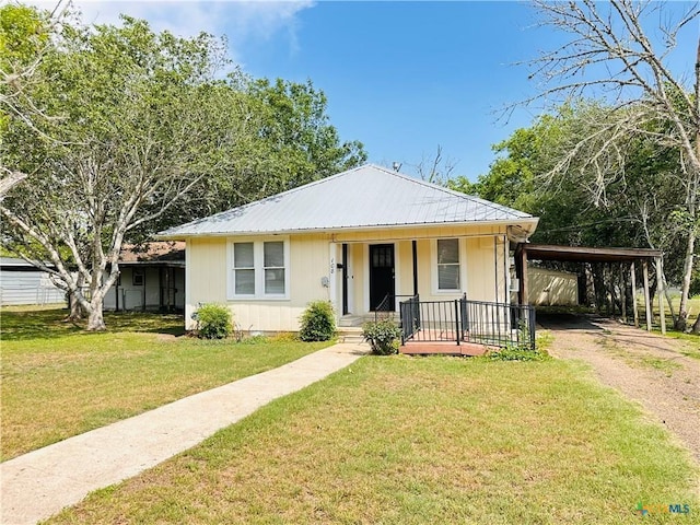 108 Nieman St, Yoakum, TX 77995 - bungalow-style home featuring a front yard, an attached carport, dirt driveway, metal roof, and a porch