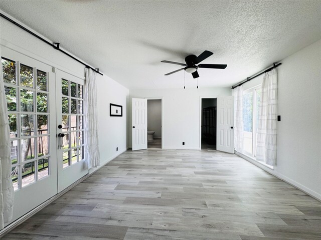 2323 Augusta Dr Unit 43, Houston, TX 77057 - spare room featuring wood finished floors, a textured ceiling, french doors, a ceiling fan, and baseboards
