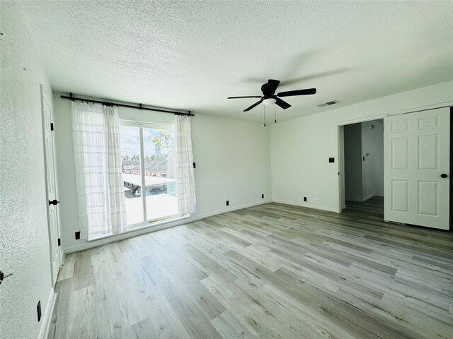2323 Augusta Dr Unit 43, Houston, TX 77057 - spare room with a ceiling fan, light wood-style floors, a textured ceiling, and baseboards