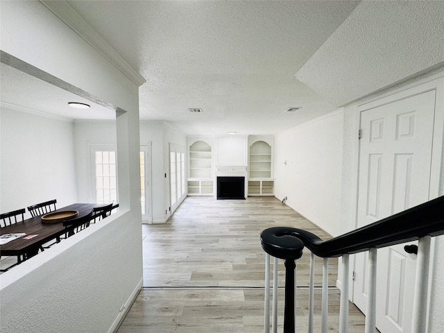 2323 Augusta Dr Unit 43, Houston, TX 77057 - hallway with a textured ceiling, light wood-style floors, built in features, crown molding, and baseboards