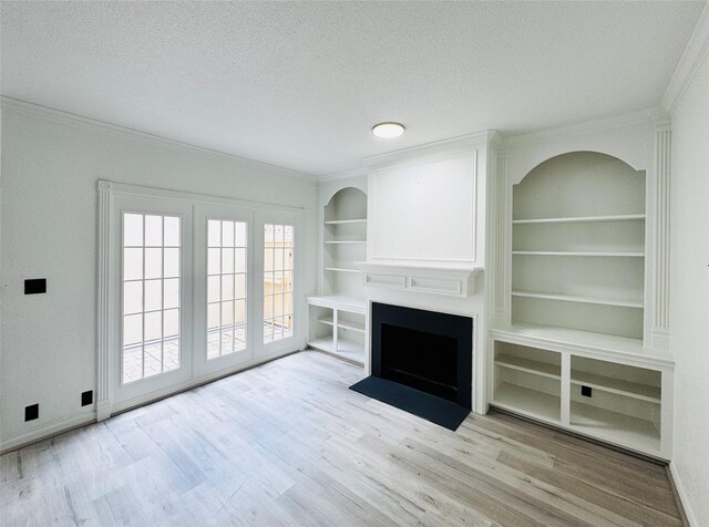 2323 Augusta Dr Unit 43, Houston, TX 77057 - unfurnished living room with wood finished floors, ornamental molding, a textured ceiling, a fireplace, and built in shelves
