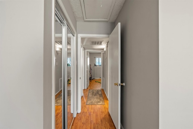 1016 E Tri Oaks Ln Unit 79, Houston, TX 77043 - hall featuring visible vents, attic access, and light wood-type flooring