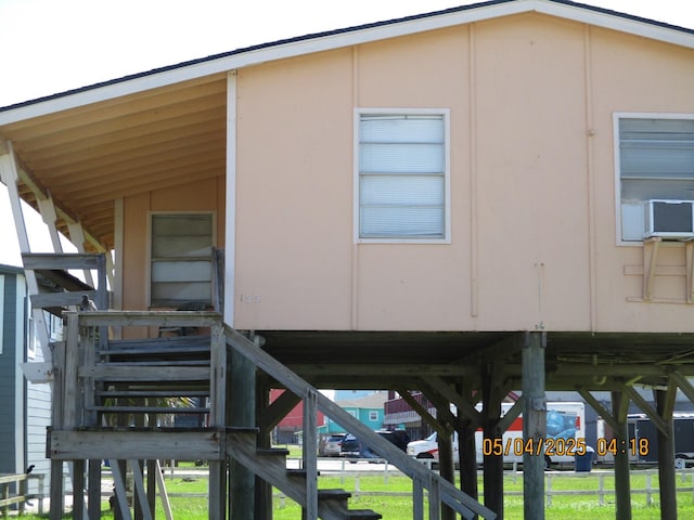 view of side of property with stairs and a yard