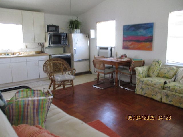 living area featuring plenty of natural light and lofted ceiling