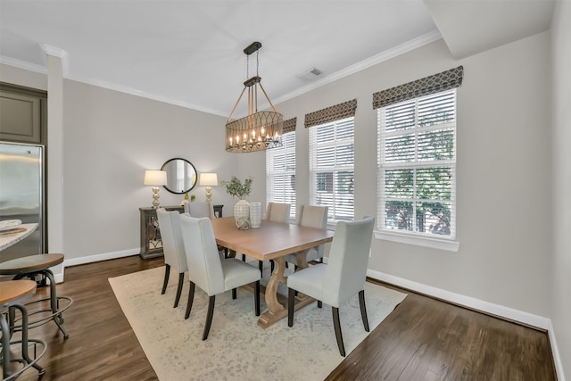 dining space featuring dark wood-style flooring, visible vents, crown molding, baseboards, and a chandelier