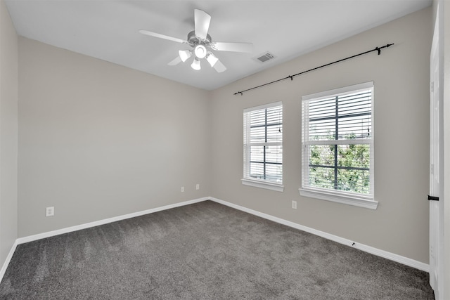 empty room with baseboards, dark carpet, and visible vents