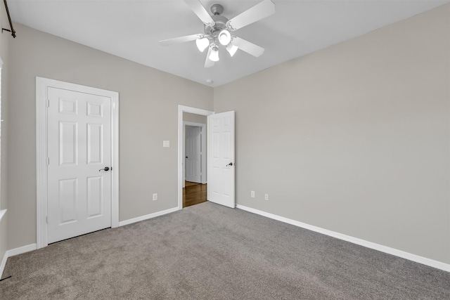 unfurnished bedroom with carpet floors, baseboards, and a ceiling fan