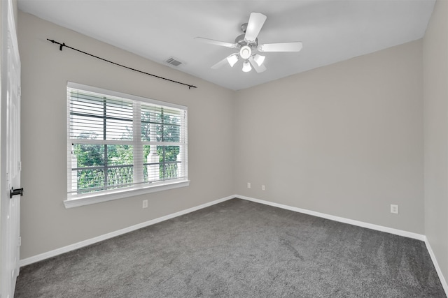carpeted empty room featuring baseboards, visible vents, and ceiling fan