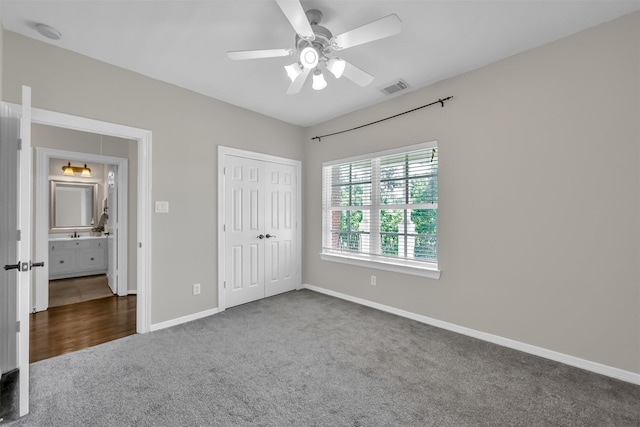 unfurnished bedroom featuring visible vents, carpet floors, a closet, baseboards, and ceiling fan