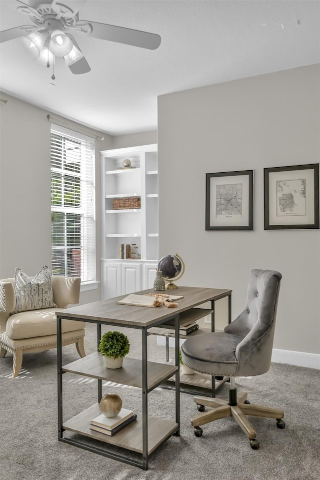 carpeted office with baseboards and a ceiling fan