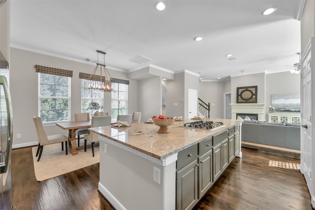 kitchen with gray cabinets, a center island, a fireplace, dark wood finished floors, and stainless steel gas stovetop