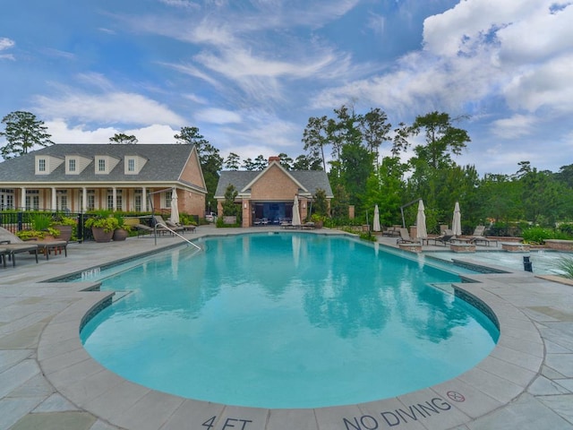 community pool featuring fence and a patio area