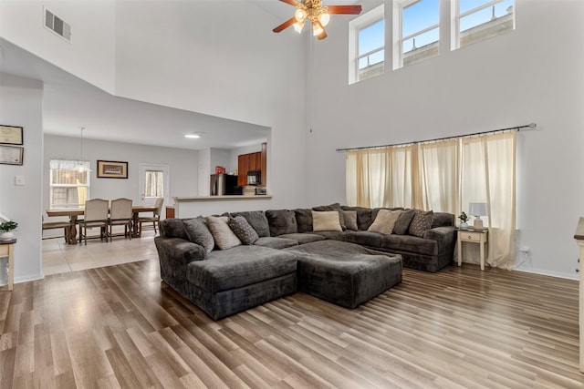 522 Pequin Rd, Crosby, TX 77532 - living room with visible vents, a ceiling fan, light wood-style flooring, and a high ceiling