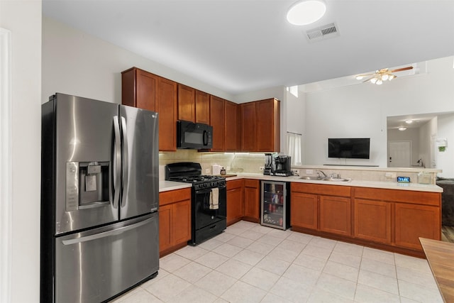 522 Pequin Rd, Crosby, TX 77532 - kitchen with backsplash, light countertops, black appliances, a peninsula, and beverage cooler