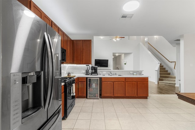 522 Pequin Rd, Crosby, TX 77532 - kitchen featuring visible vents, a peninsula, beverage cooler, a ceiling fan, and black appliances