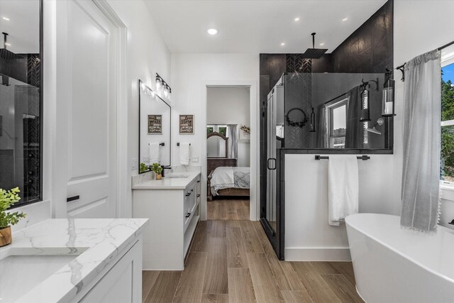 224 Kellog, Fischer, TX 78623 - ensuite bathroom with a shower stall, vanity, a soaking tub, recessed lighting, and wood finished floors