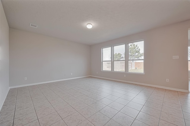 24114 Morrison Ln, Katy, TX 77493 - empty room featuring a textured ceiling, baseboards, light tile patterned flooring, and visible vents