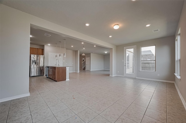 24114 Morrison Ln, Katy, TX 77493 - unfurnished living room featuring visible vents, stairs, baseboards, a sink, and light tile patterned floors