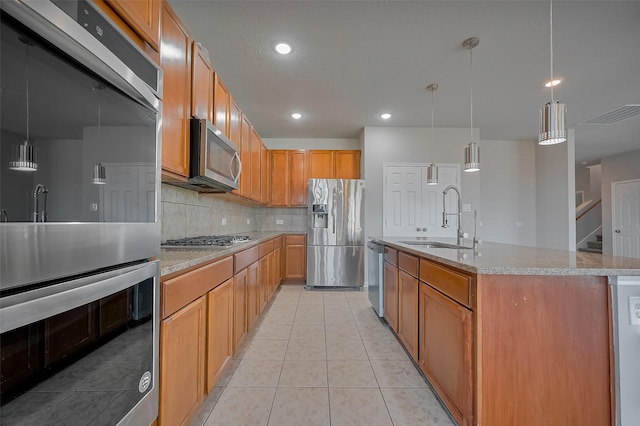 24114 Morrison Ln, Katy, TX 77493 - kitchen featuring light tile patterned flooring, a center island with sink, a sink, appliances with stainless steel finishes, and backsplash