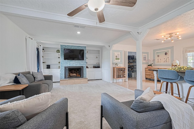 13018 Vernon Rd, Cypress, TX 77429 - living area featuring a stone fireplace, a ceiling fan, a textured ceiling, and built in shelves