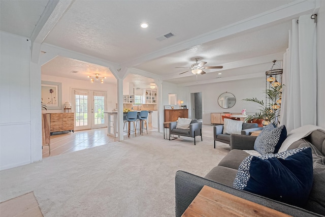 13018 Vernon Rd, Cypress, TX 77429 - living area with light carpet, beam ceiling, french doors, ceiling fan, and a chandelier