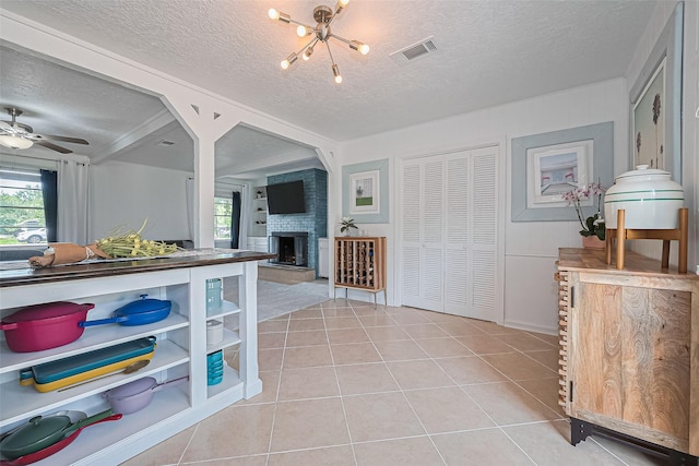 13018 Vernon Rd, Cypress, TX 77429 - kitchen featuring a textured ceiling, healthy amount of natural light, a fireplace, light tile patterned flooring, and a chandelier