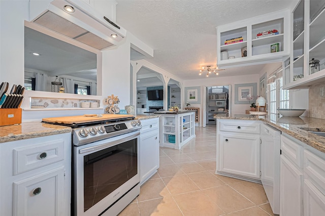 13018 Vernon Rd, Cypress, TX 77429 - kitchen with stainless steel gas range, under cabinet range hood, a peninsula, white cabinets, and light tile patterned floors