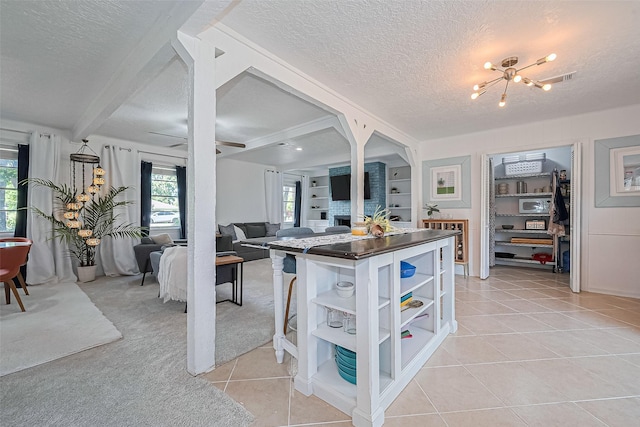 13018 Vernon Rd, Cypress, TX 77429 - kitchen featuring open shelves, a textured ceiling, light tile patterned flooring, a chandelier, and dark countertops