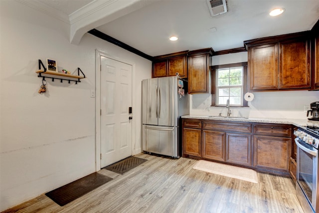 708 Gresham St, Baytown, TX 77520 - kitchen featuring light wood-type flooring, a sink, appliances with stainless steel finishes, and crown molding