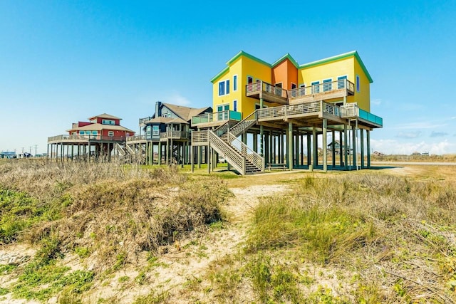 2386 Hwy 87, Gilchrist, TX 77617 - rear view of house featuring a balcony, a deck, and stairway