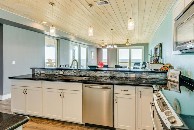2386 Hwy 87, Gilchrist, TX 77617 - kitchen featuring white cabinets, stainless steel appliances, a wealth of natural light, and a sink