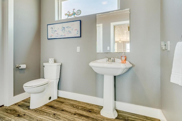 2386 Hwy 87, Gilchrist, TX 77617 - half bath with baseboards, plenty of natural light, toilet, and wood finished floors