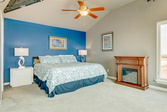 2386 Hwy 87, Gilchrist, TX 77617 - carpeted bedroom with baseboards, vaulted ceiling, a glass covered fireplace, and ceiling fan