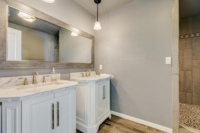 2386 Hwy 87, Gilchrist, TX 77617 - full bathroom featuring baseboards, two vanities, a sink, and wood finished floors