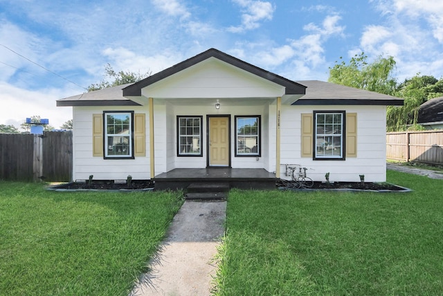 bungalow-style home with fence, a porch, and a front yard