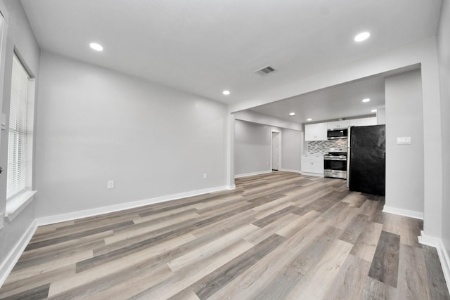 unfurnished living room featuring recessed lighting, light wood-type flooring, and visible vents