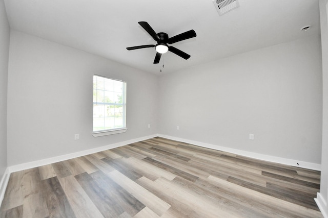 empty room with visible vents, baseboards, ceiling fan, and wood finished floors