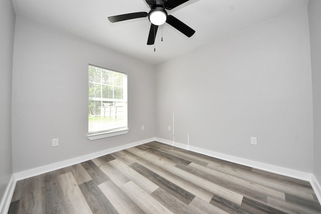 spare room featuring baseboards, ceiling fan, and wood finished floors