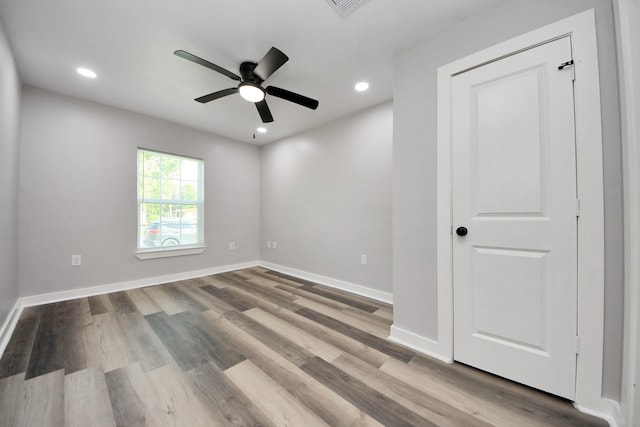 empty room featuring visible vents, wood finished floors, baseboards, recessed lighting, and a ceiling fan