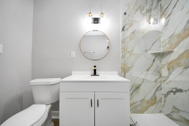 bathroom with vanity, a marble finish shower, and toilet