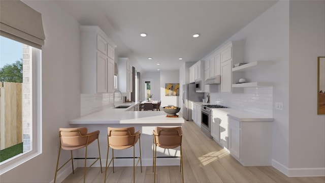 kitchen featuring light countertops, a sink, appliances with stainless steel finishes, and tasteful backsplash