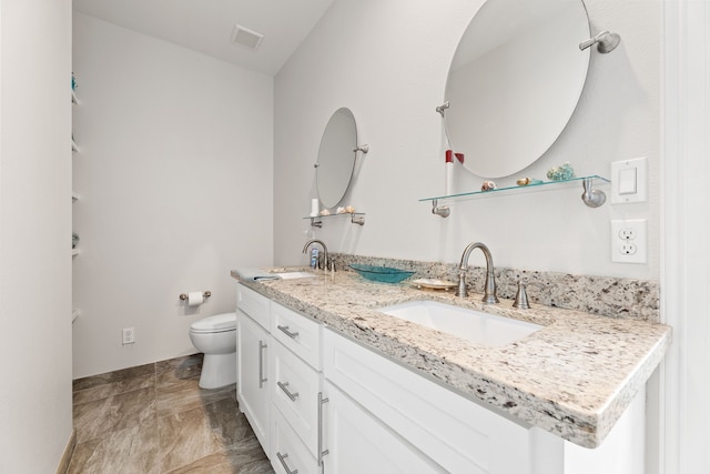 full bath featuring double vanity, toilet, baseboards, and a sink