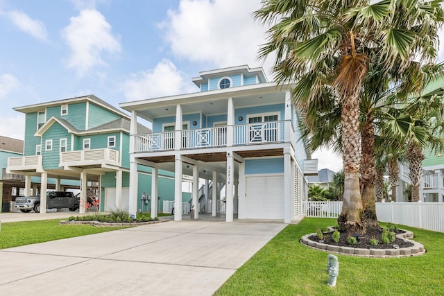 coastal inspired home featuring a garage, fence, a carport, and concrete driveway