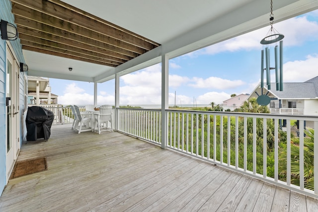 wooden deck with a grill and outdoor dining space